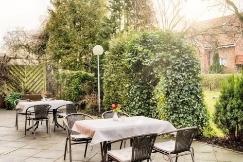two tables and chairs with flowers on top of a patio at Hotel Apfelblüte in Wendorf