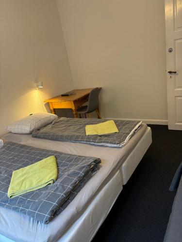 two beds in a room with yellow towels on them at Siesta Vejle in Vejle