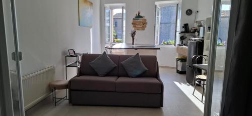 a living room with a couch and a kitchen at Suite Moulin de la Calade -Tower View, Heart of Provence & AC in Le Luc