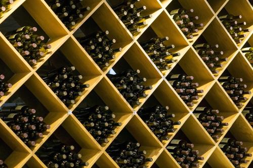 a wall filled with lots of different types of wine bottles at AGROLOGY LUX - 4 BEDROOM Luxurious villa on an Agricultural Haven Retreat in Sálakos