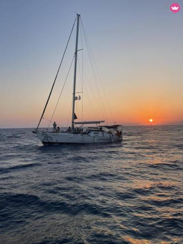 a sail boat in the ocean at sunset at AGROLOGY LUX - 4 BEDROOM Luxurious villa on an Agricultural Haven Retreat in Sálakos