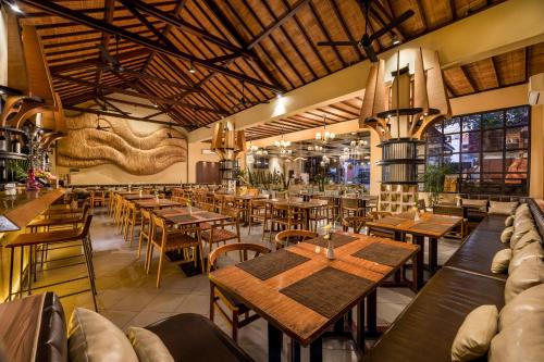 an empty restaurant with wooden tables and chairs at Adhi Jaya Hotel in Kuta