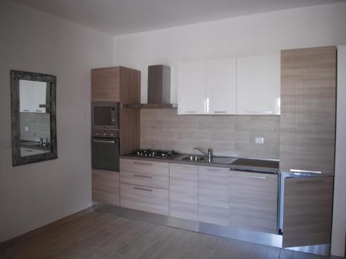 a kitchen with wooden cabinets and a sink and a mirror at Surf House Cabo Verde in Santa Maria