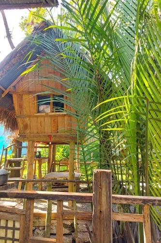 a tree house on a deck with a palm tree at Surfer's Villa La Union in San Juan