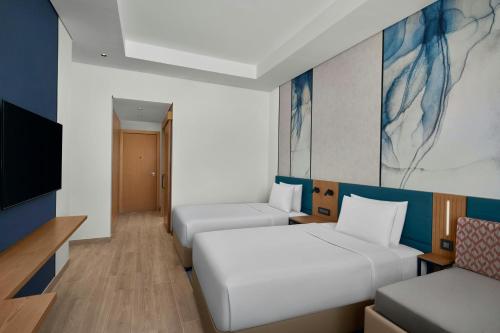 a hotel room with two beds and a tv at Courtyard by Marriott Makkah in Makkah