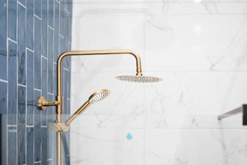 a shower with a shower head in a bathroom at Deacons Bank Penthouses, Two Luxury Apartments in Chapel en le Frith