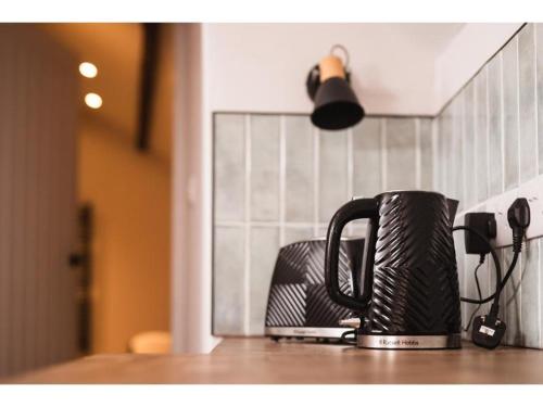 a black coffee cup sitting on a kitchen counter at Deacons Bank Penthouses, Two Luxury Apartments in Chapel en le Frith