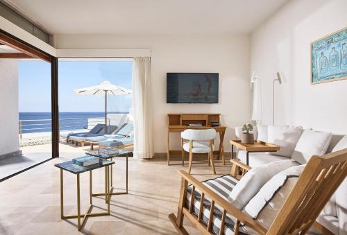 a living room with a couch and a table at St. Nicolas Bay Resort Hotel & Villas in Agios Nikolaos