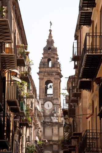 a building with a clock tower in the middle of a street at Cialoma B&B in Palermo