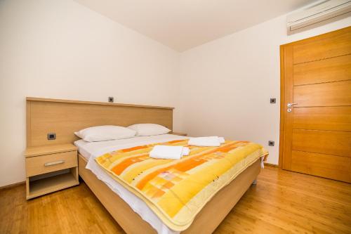 a bedroom with a large bed and a wooden door at Villa Tucepi Beach in Tučepi