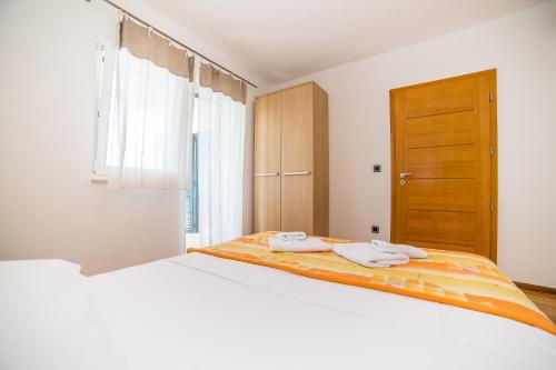 a bedroom with a bed with two towels on it at Villa Tucepi Beach in Tučepi