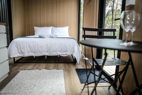 a bedroom with a bed and a table with a chair at Solitary Islands Farm Tiny House by Tiny Away in Arrawarra
