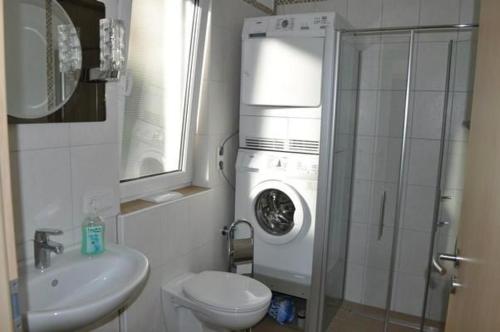 a bathroom with a toilet and a washing machine at Ferienwohnung Am Waldesrand in Schmallenberg