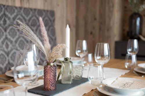 a dining room table with a candle and wine glasses at Apparthaus Anderl in Zellbergeben