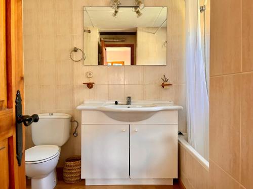 a bathroom with a sink and a toilet and a mirror at Mirador de la Neu in Pla de l'Ermita