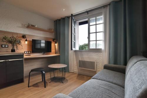 un salon avec un canapé et une table dans l'établissement Pierrette 12 - 200m de la plage parking privé, à Fréhel