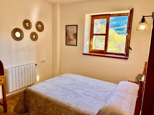 a bedroom with a bed and a window at Mirador de la Neu in Pla de l'Ermita
