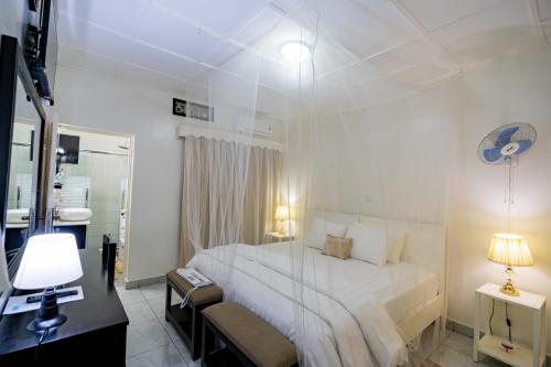 a bedroom with a white bed with a glass wall at Blue Veil Villa Hotel in Kigali