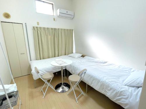 a hospital room with a bed and a table and chairs at Odoホテル セルフチェックイン in Fukuoka