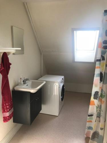 a bathroom with a sink and a washing machine at Svanegade 1 , 2 sal in Thyborøn