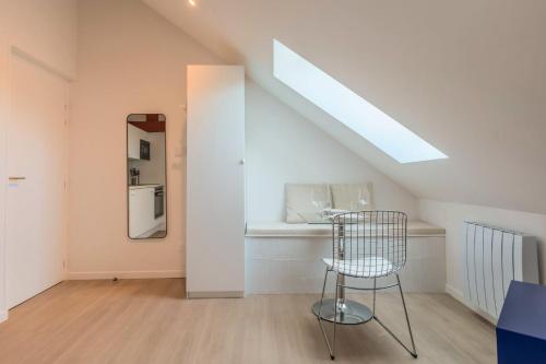 une cuisine avec une chaise dans une pièce dans l'établissement Studio sous les combles côté rue, parking gratuit, à Villeneuve d'Ascq