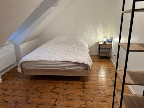 une chambre avec un lit et un escalier dans l'établissement Gîte de la Source, à Feuchy