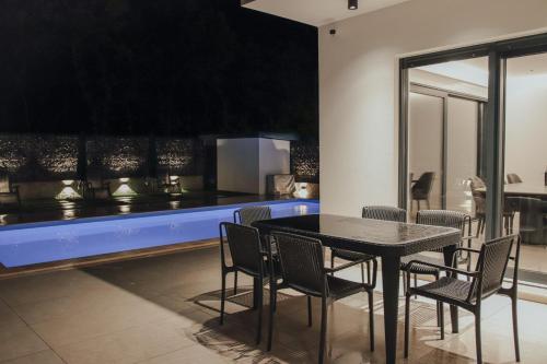 Un comedor con mesa y sillas y una cocina. en Villa St.Benedict, en Međugorje
