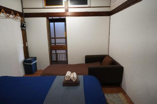 a bedroom with a bed and a couch and a window at SYMPOSION Locanda in Kamakura