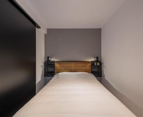 a small bedroom with a white bed in it at Apartamentos Turísticos de Soria Centro NF in Soria