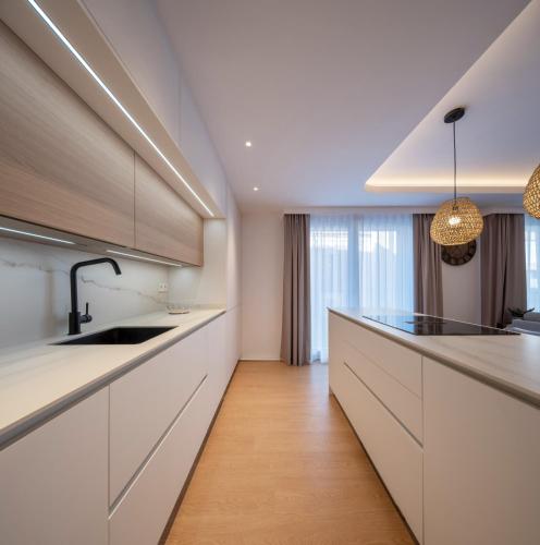 a kitchen with white cabinets and a kitchen island at Apartamentos Turísticos de Soria Centro NF in Soria