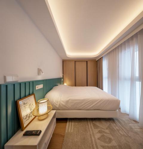 a bedroom with a bed and a table with a picture at Apartamentos Turísticos de Soria Centro NF in Soria
