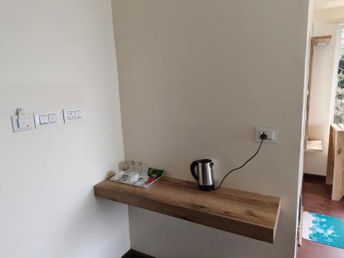 a kitchen with a wooden shelf on the wall at Lamahatta Clouds Hotel & Restaurant in Takdāh