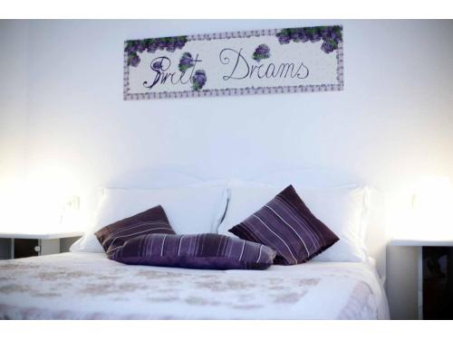 a bed with two pillows and a sign on the wall at Apartments Elda in Makarska