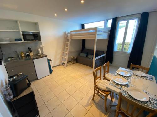 - une cuisine et une salle à manger avec une table et des lits superposés dans l'établissement Studio proche du Futuroscope, à Aquascope, à Chasseneuil-du-Poitou