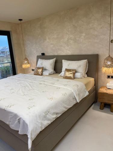 a bedroom with a large bed with white sheets and pillows at U NÁS DOMA v LUŽICÍCH in Lužice