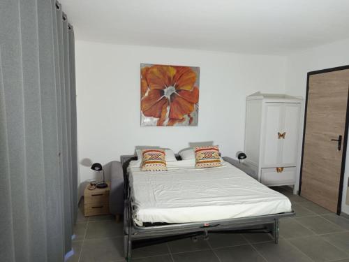 a small bedroom with a bed with white sheets and pillows at Sympa Studio totalement équipé in Saint-Germain-de-Joux