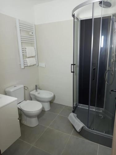 a white bathroom with a toilet and a shower at Sympa Studio totalement équipé in Saint-Germain-de-Joux