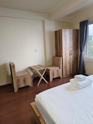 a bedroom with a bed and two chairs and a window at Lamahatta Clouds Hotel & Restaurant in Takdāh