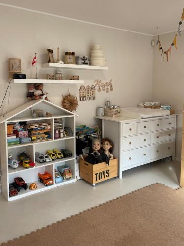 a childs room with a white dresser and shelves at U NÁS DOMA v LUŽICÍCH in Lužice