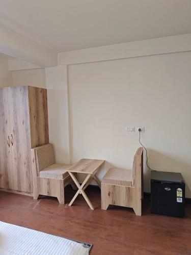 two chairs and a table in a room at Lamahatta Clouds Hotel & Restaurant in Takdāh