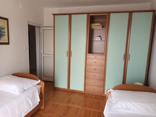 a bedroom with two beds and a closet at Apartmani Dajana in Primošten