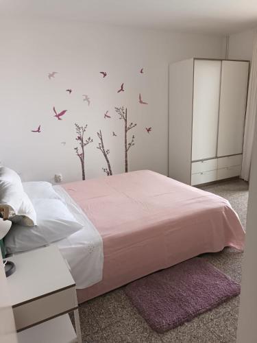 a bedroom with a bed with birds on the wall at Apartmani Dajana in Primošten