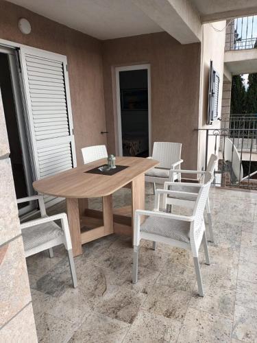 a wooden table and chairs on a patio at Apartmani Dajana in Primošten