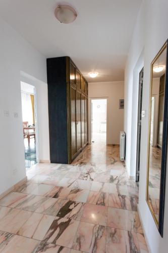 an empty hallway with a marble floor and glass doors at Apartmani Dajana in Primošten