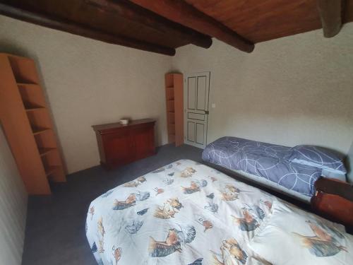 a bedroom with a bed with a comforter on it at Gîte des Ailes in Vorey