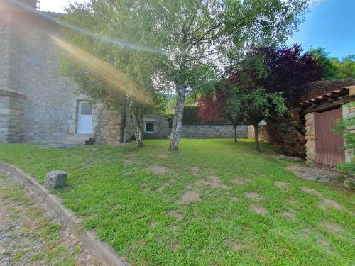 a rainbow in a yard with a tree and a building at Gîte des Ailes in Vorey