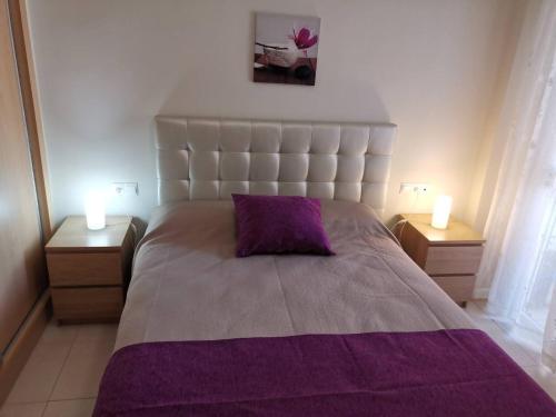 ein Schlafzimmer mit einem großen Bett mit einer lila Decke in der Unterkunft Vera Playa Apto 1-4 Personas Piscina Parking WI-FI in Playas de Vera