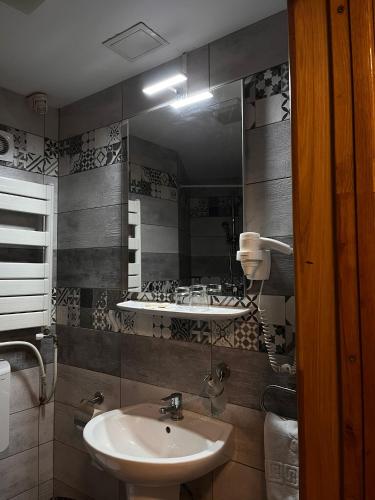a bathroom with a sink and a mirror at Hotel Dambovita in Târgovişte
