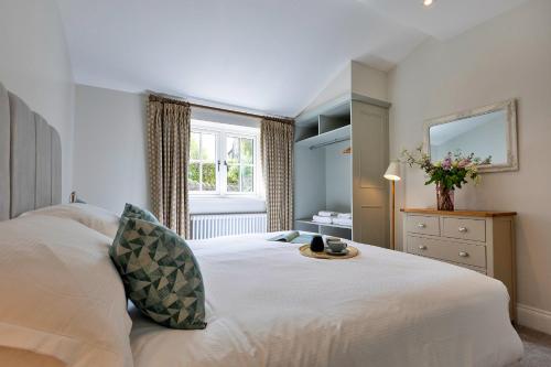 a bedroom with a large white bed with a mirror at Finest Retreats - Cherry Cottage Nr Grantley Hall in Grantley