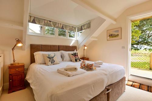 a bedroom with a large white bed with a window at Finest Retreats - The Old Estate Office Nr Grantley Hall in Grantley